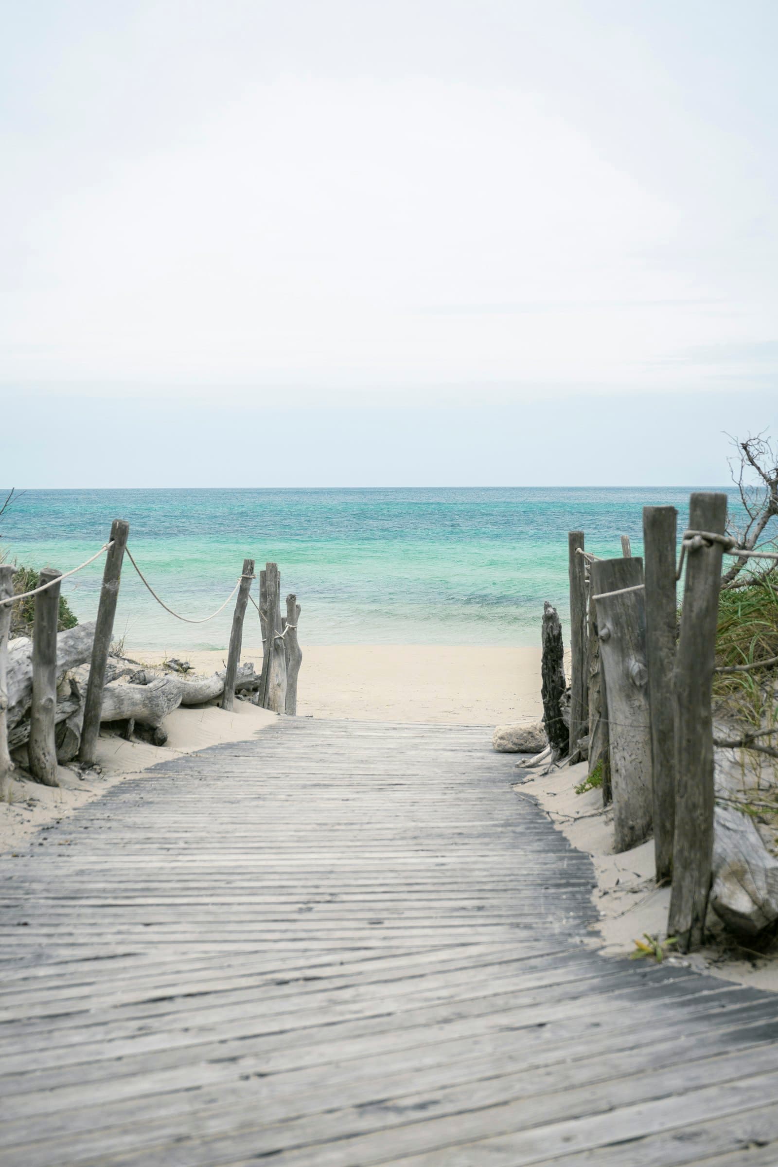 A wooden boardwalk leading through the dunes to the ocean