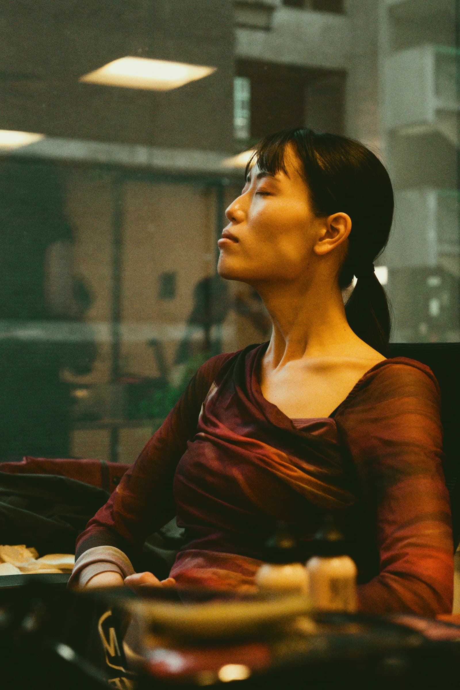 A woman with her eyes closed, face turned toward warm sunlight
