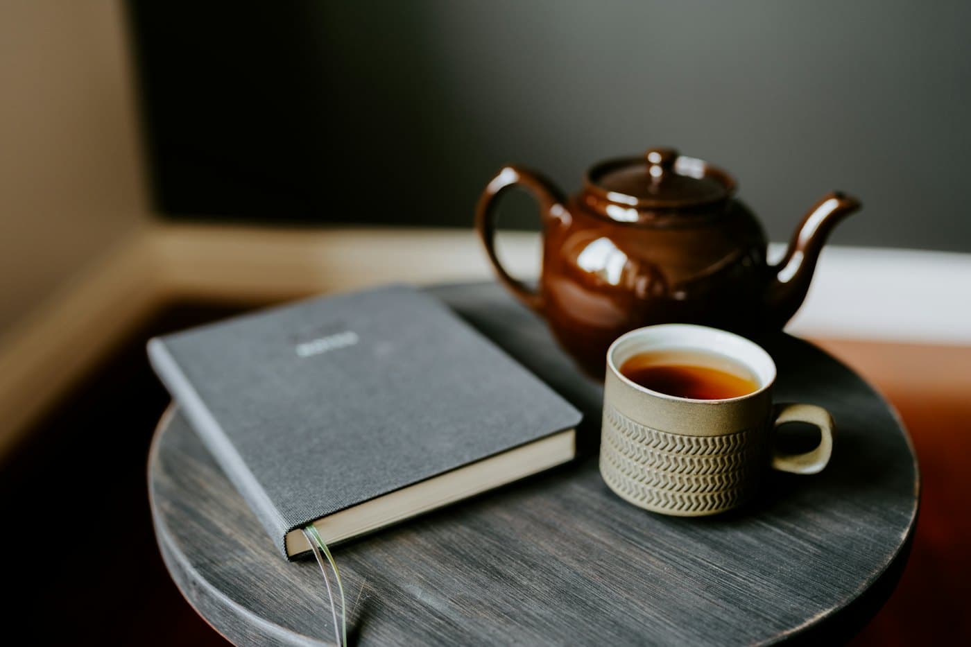 A cup of tea beside a closed notebook